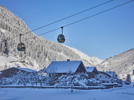 A skier is going down the snow-covered slope. In the background, majestic mountains are visible.