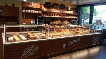 A well-designed bakery with a selection of fresh baked goods and pastries. Bright lighting and an inviting ambiance create a cozy atmosphere.