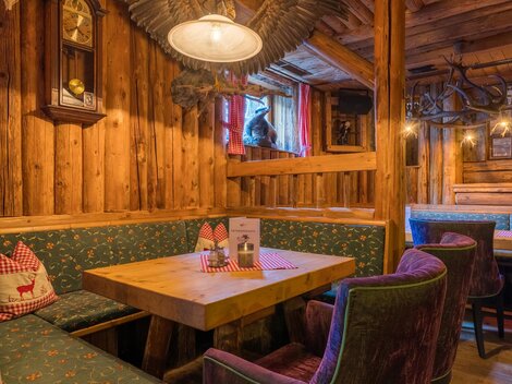 A cozy parlor with wood-paneled walls and comfortable seating. Menu cards are on the table and the atmosphere is inviting.