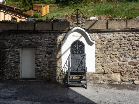 A historic stone building with a black staircase and a decorative door. At the top, the word "Maria" is visible. | © Bernhard Gruber – Photography